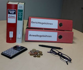 Foto mit zwei stehenden Kommentaren Streitwert und zwei liegenden Ordnern Gerichtsgebühren, Anwaltsgebühren im Hintergrund, vorne im Bild links ein Taschenrechner, in der Mitte einige Geldmünzen sowie rechts im Bild eine Brille und Kugelschreiber. Das Bild zeigt zwei stehende Kommentare Streitwert und zwei liegende Ordnern Gerichtsgebühren, Anwaltsgebühren im Hintergrund, vorne im Bild links ein Taschenrechner, in der Mitte einige Geldmünzen sowie rechts eine Brille und Kugelschreiber.